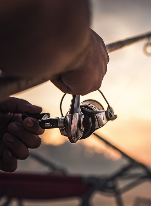 Fishing,Rod,Wheel,Closeup,,Man,Fishing,With,A,Beautiful,Sunrise